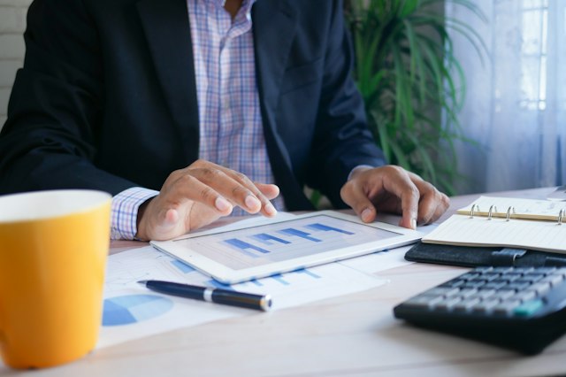 Un professionnel étudie des documents et graphiques de gestion.