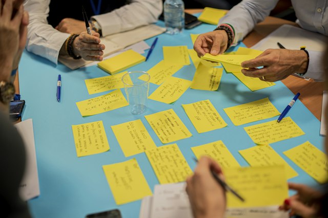 Un groupe organise des idées sur des notes pendant un atelier.